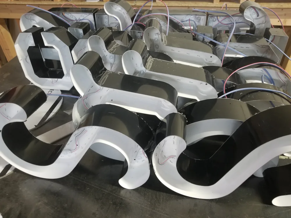 Open fabricated metal letter shells during shop production