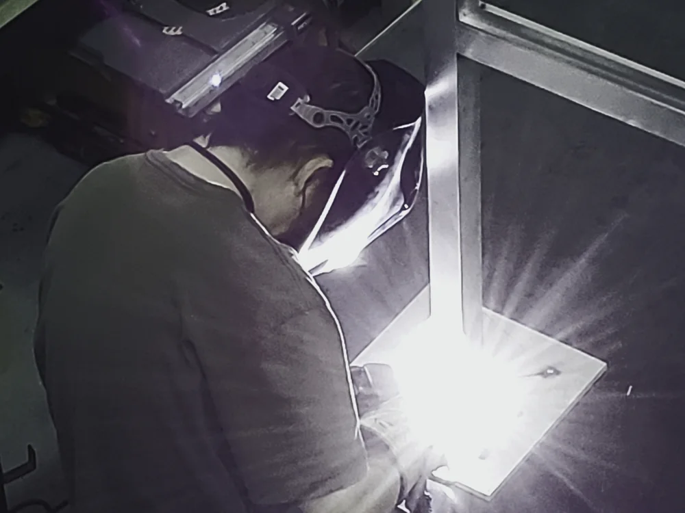 Welding a fabricated metal sign component in the S2 shop