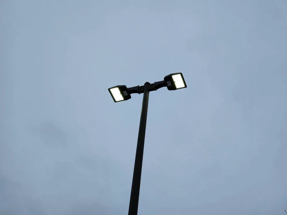Dual LED parking lot fixtures operating after exterior lighting service