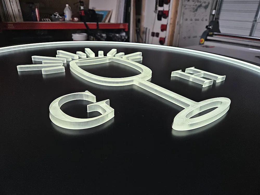 Close detail of illuminated push-thru acrylic on a black aluminum sign face