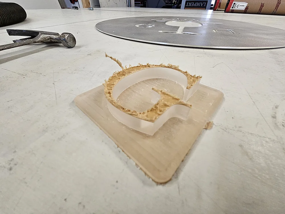 Acrylic push-thru component being machined for a custom illuminated sign